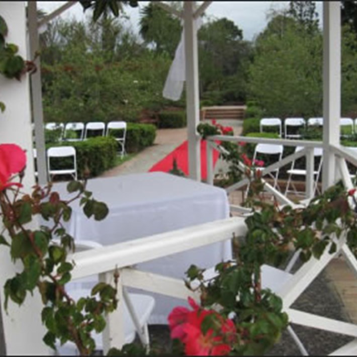 Table, chairs and aisle runner wedding ceremony set up in the St Kilda Botanical Gardens rose garden rotunda