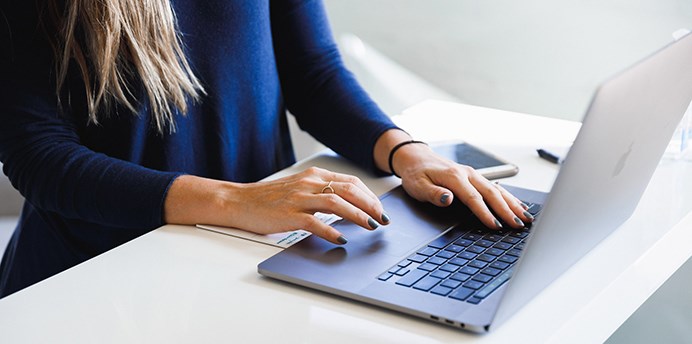 Woman typing on a laptop computer - photo by Luke Southern on Unsplash