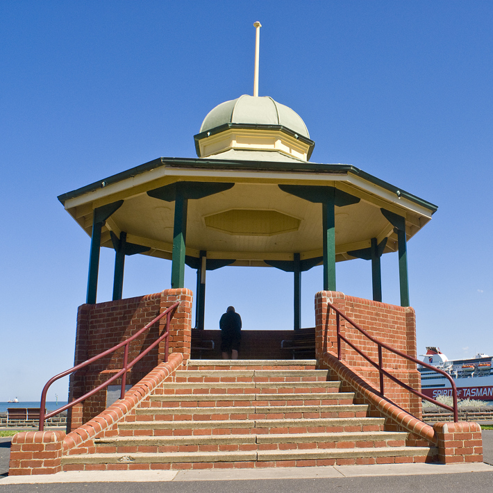 Port Melbourne bandstand rotunda provides a viewing platform over the Bay towards the Pier with the Spirit of Tasmania docked