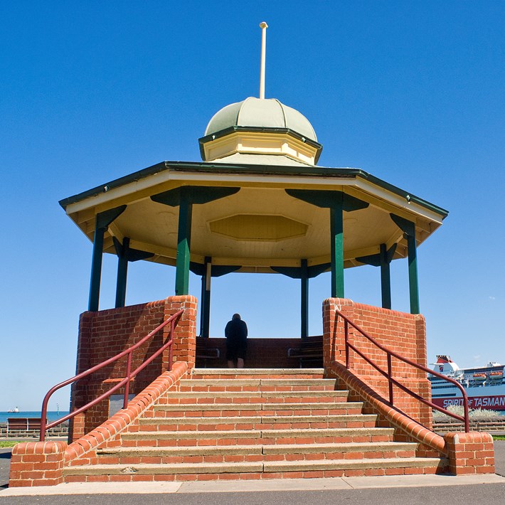 Port Melbourne bandstand rotunda provides a viewing platform over the Bay towards the Pier with the Spirit of Tasmania docked