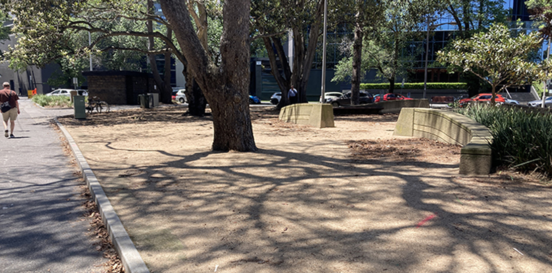 Photo showing large tree, entry and sandy area of Kings Way Reserve in Melbourne