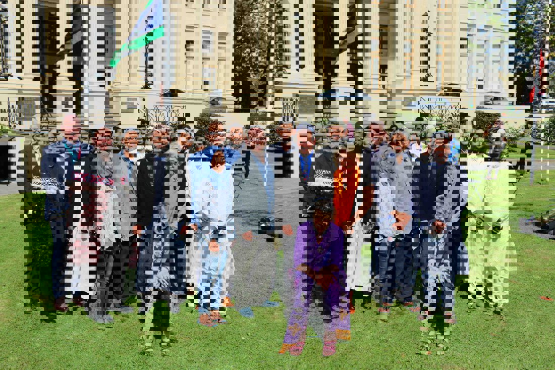 A group of people in religious clothing seated and standing in front of St Kilda Town Hall 