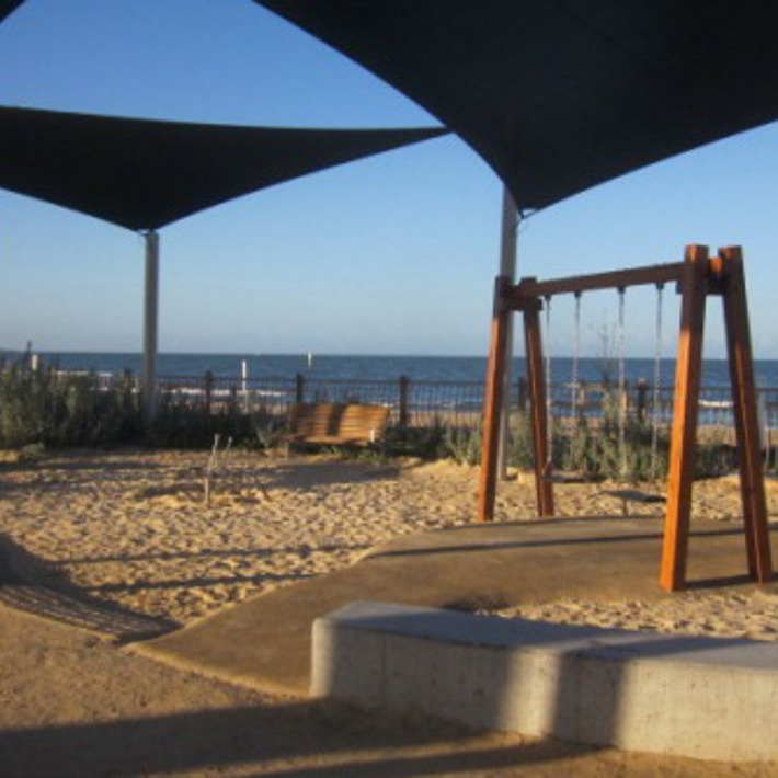 Swings and seating under shade sails at Plum Garland playground