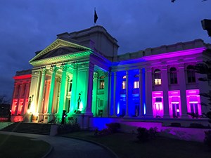 St Kilda Town Hall lit up at night with rainbow floodlights to mark support for marriage equality