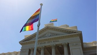 The Rainbox flag flying in front of and top of the St Kilda Town Hall on a sunny day
