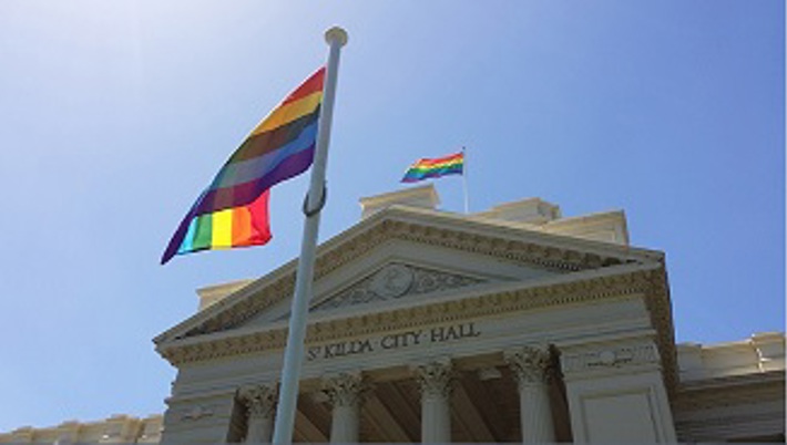 The Rainbox flag flying in front of and top of the St Kilda Town Hall on a sunny day