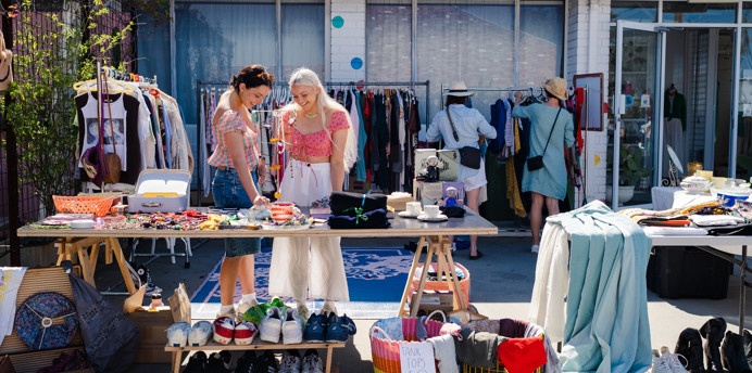Two young women looking at items at a garage sale