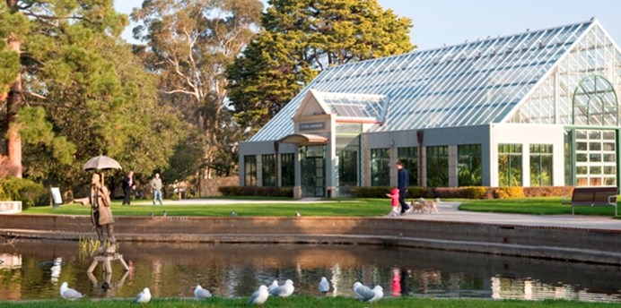 The St Kilda Botanical Gardens pond with Rain Man fountain with the conservatory in the background
