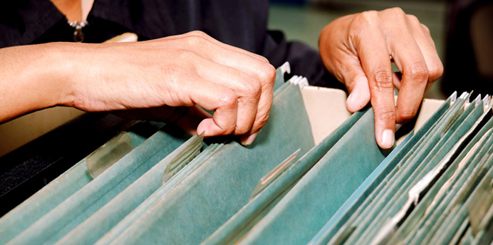 A person searches through a filing cabinet