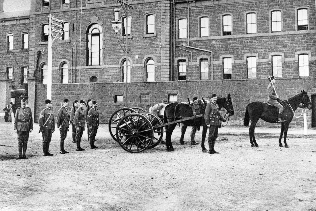 Bluestone Army barracks uniformed soldiers parade in front of it