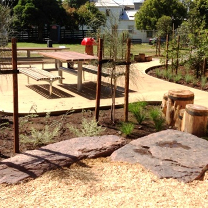 Tables and benches are provided to enjoy a picnic surrounded by planted garden beds