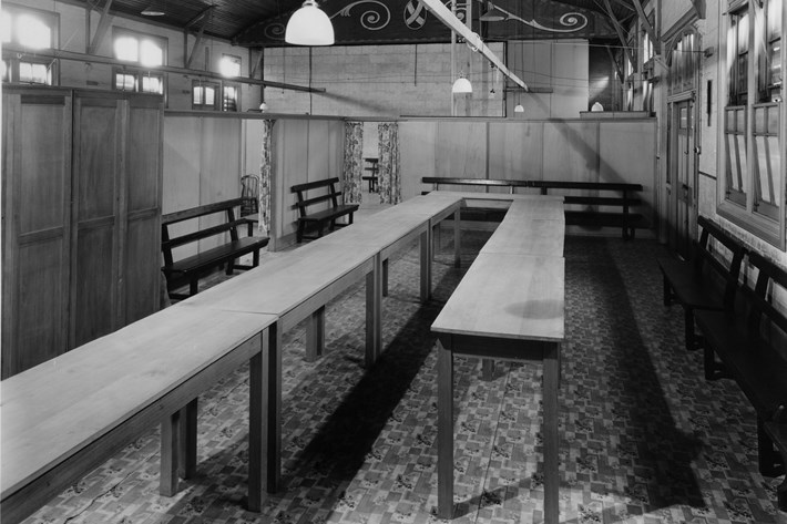 interior of an old hall fitted out with partitions and a long table 